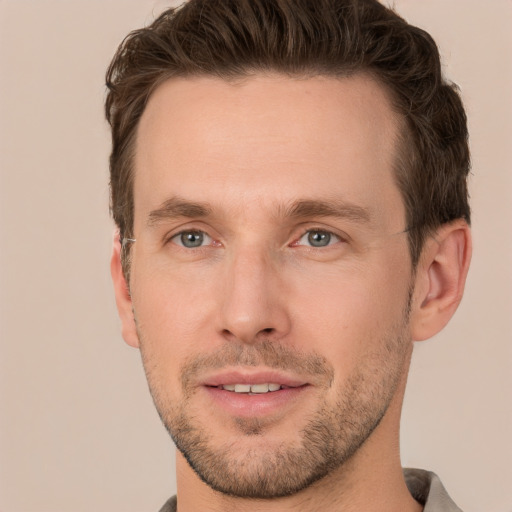 Joyful white young-adult male with short  brown hair and grey eyes