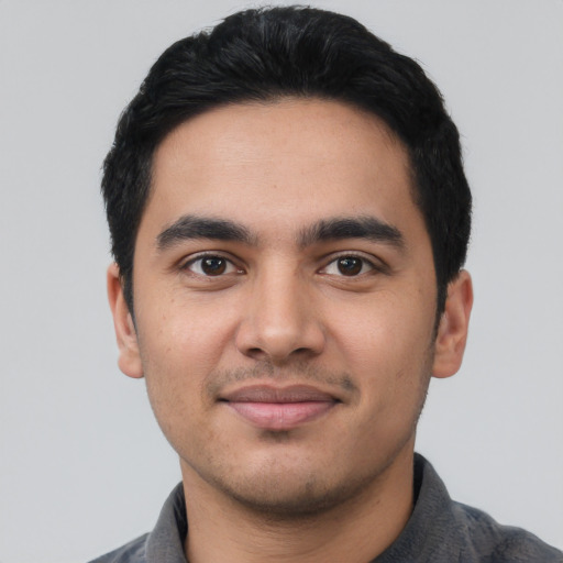 Joyful latino young-adult male with short  black hair and brown eyes