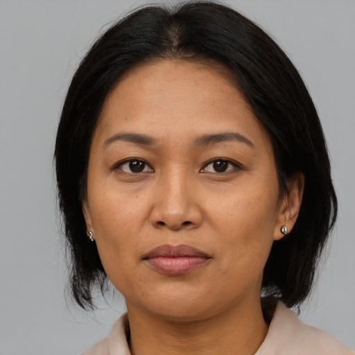 Joyful asian adult female with medium  brown hair and brown eyes