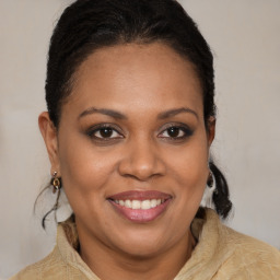 Joyful black young-adult female with long  brown hair and brown eyes