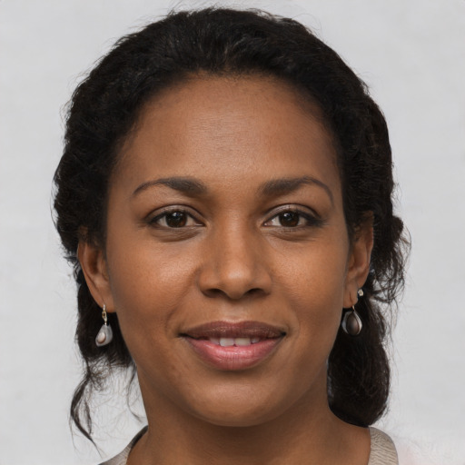 Joyful black young-adult female with medium  brown hair and brown eyes