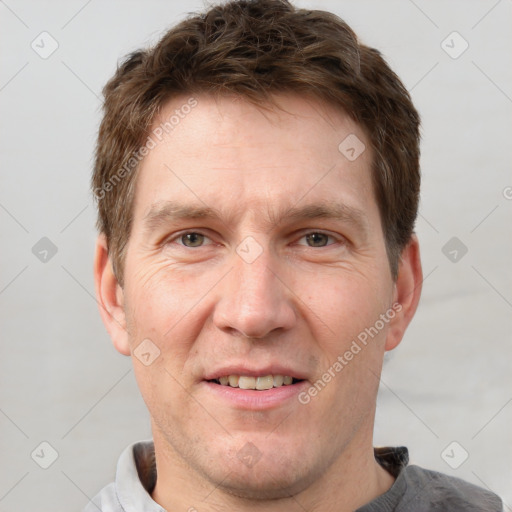 Joyful white adult male with short  brown hair and grey eyes