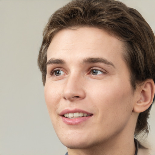 Joyful white young-adult male with short  brown hair and green eyes