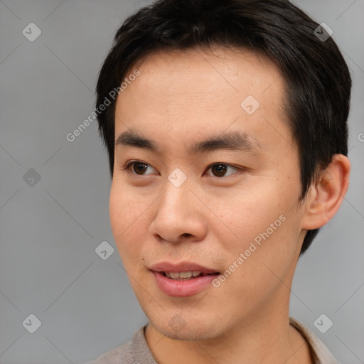 Joyful asian young-adult male with short  brown hair and brown eyes