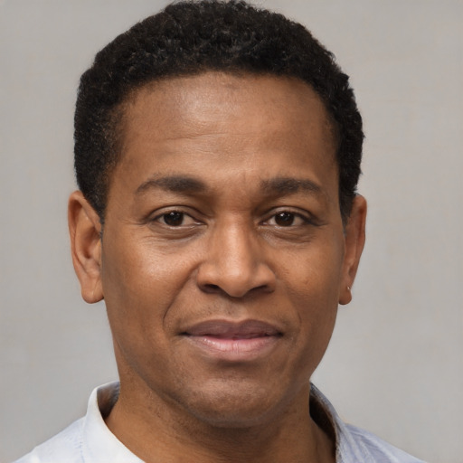 Joyful black adult male with short  brown hair and brown eyes