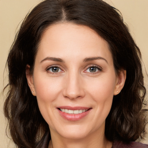 Joyful white adult female with long  brown hair and brown eyes