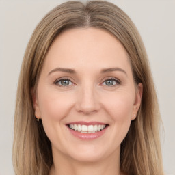 Joyful white young-adult female with long  brown hair and grey eyes