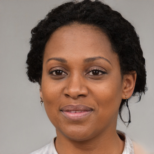 Joyful black adult female with short  black hair and brown eyes