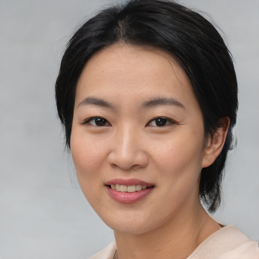 Joyful asian young-adult female with medium  black hair and brown eyes