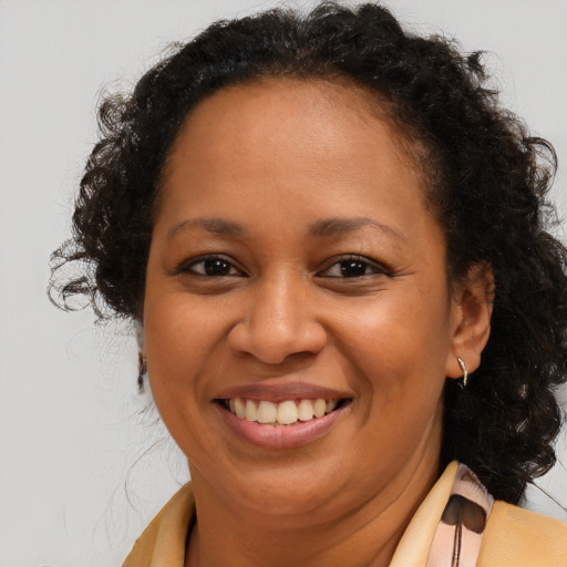 Joyful black adult female with long  brown hair and brown eyes