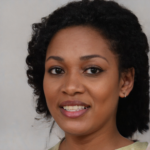Joyful black young-adult female with medium  black hair and brown eyes