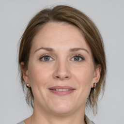 Joyful white adult female with medium  brown hair and grey eyes