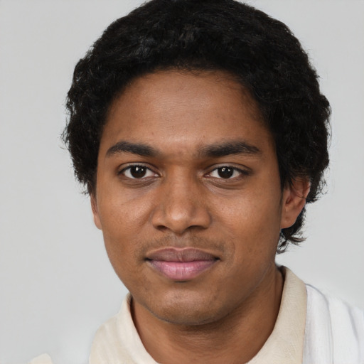 Joyful black young-adult male with short  black hair and brown eyes