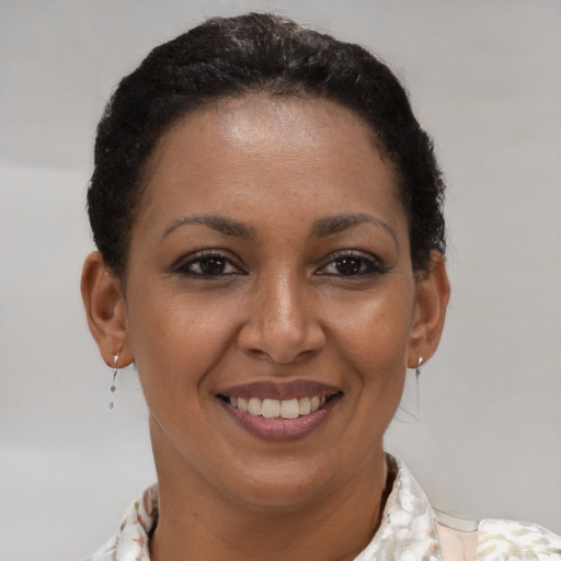 Joyful black young-adult female with short  brown hair and brown eyes