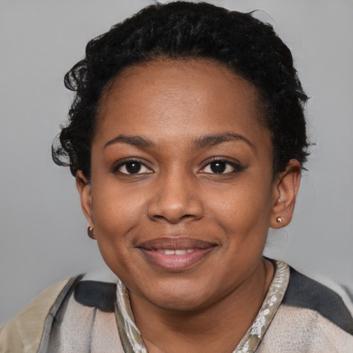Joyful black young-adult female with short  black hair and brown eyes