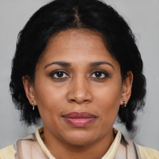 Joyful latino adult female with medium  brown hair and brown eyes