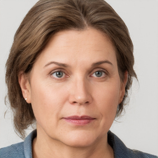 Joyful white adult female with medium  brown hair and grey eyes