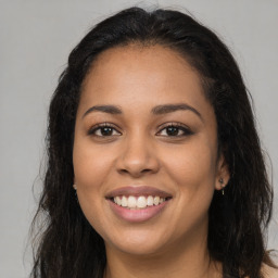 Joyful latino young-adult female with long  brown hair and brown eyes