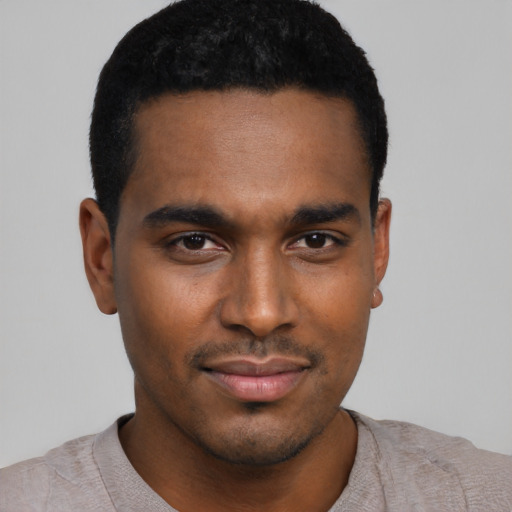 Joyful black young-adult male with short  black hair and brown eyes