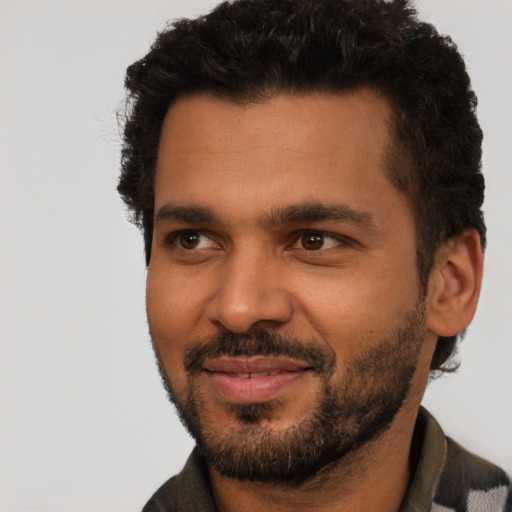 Joyful black young-adult male with short  black hair and brown eyes