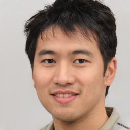 Joyful asian young-adult male with short  brown hair and brown eyes