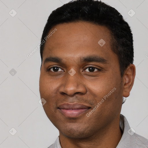 Joyful black young-adult male with short  black hair and brown eyes