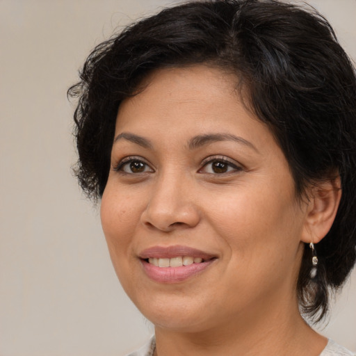 Joyful latino adult female with medium  brown hair and brown eyes