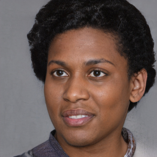 Joyful black young-adult female with short  black hair and brown eyes