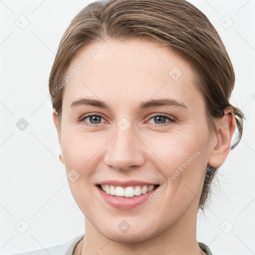 Joyful white young-adult female with short  brown hair and grey eyes