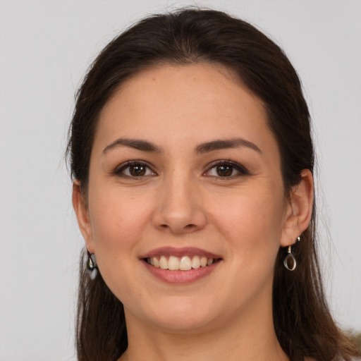 Joyful white young-adult female with long  brown hair and brown eyes