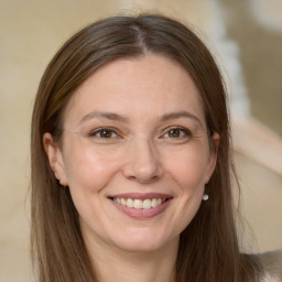 Joyful white adult female with long  brown hair and grey eyes