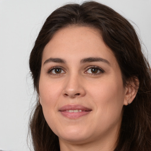 Joyful white young-adult female with long  brown hair and brown eyes