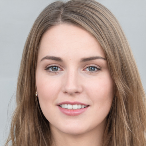 Joyful white young-adult female with long  brown hair and grey eyes