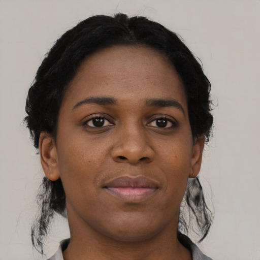 Joyful black young-adult female with short  black hair and brown eyes