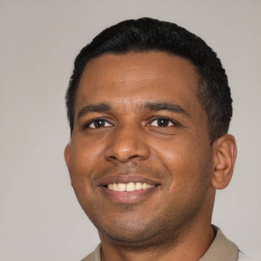 Joyful latino young-adult male with short  black hair and brown eyes