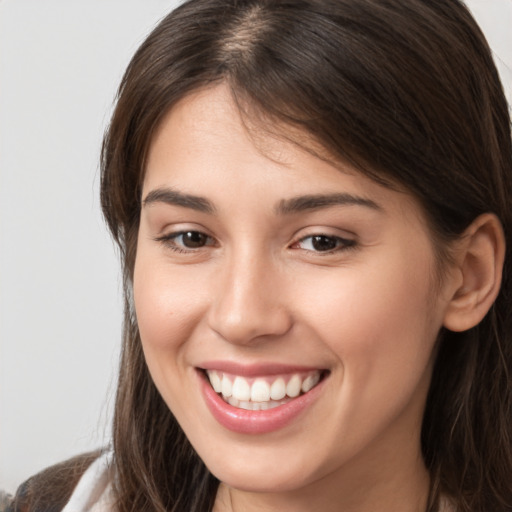 Joyful white young-adult female with long  brown hair and brown eyes