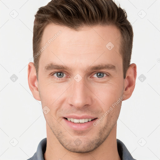 Joyful white young-adult male with short  brown hair and grey eyes