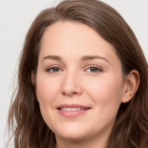 Joyful white young-adult female with long  brown hair and grey eyes