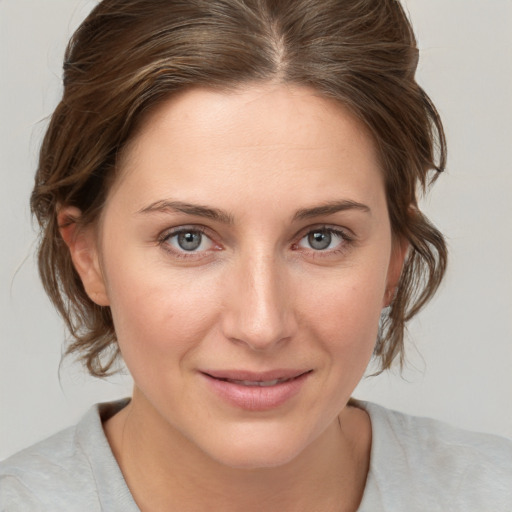 Joyful white young-adult female with medium  brown hair and grey eyes