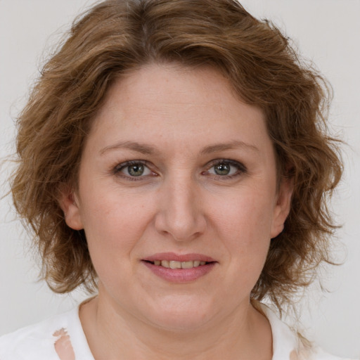 Joyful white adult female with medium  brown hair and green eyes