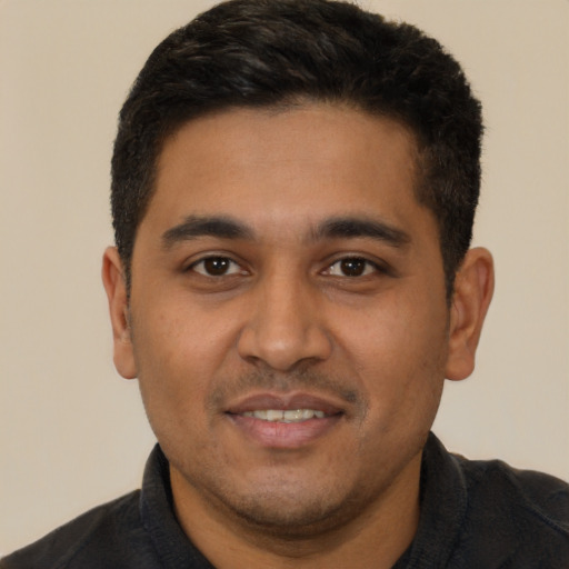 Joyful latino young-adult male with short  black hair and brown eyes