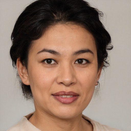 Joyful latino adult female with medium  brown hair and brown eyes
