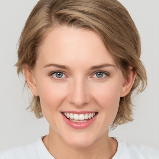 Joyful white young-adult female with medium  brown hair and grey eyes