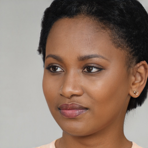 Joyful black young-adult female with short  brown hair and brown eyes