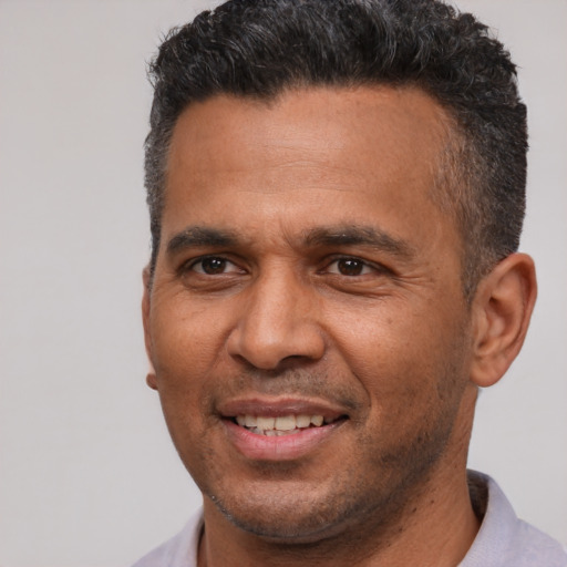 Joyful latino adult male with short  brown hair and brown eyes