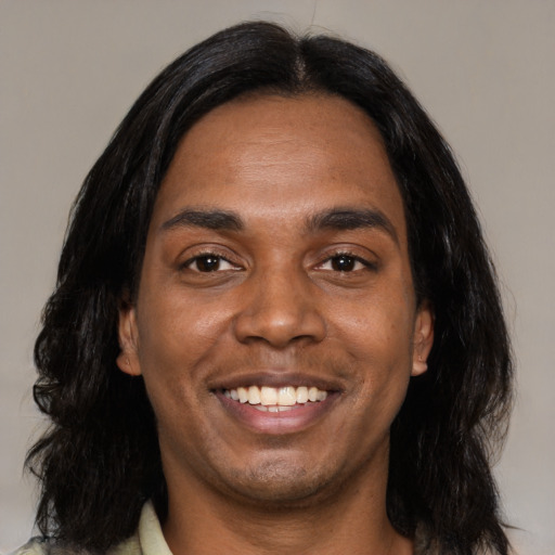 Joyful black young-adult male with medium  black hair and brown eyes