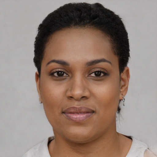 Joyful black young-adult female with short  black hair and brown eyes