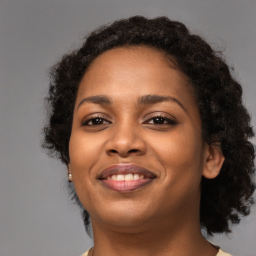 Joyful black young-adult female with medium  black hair and brown eyes