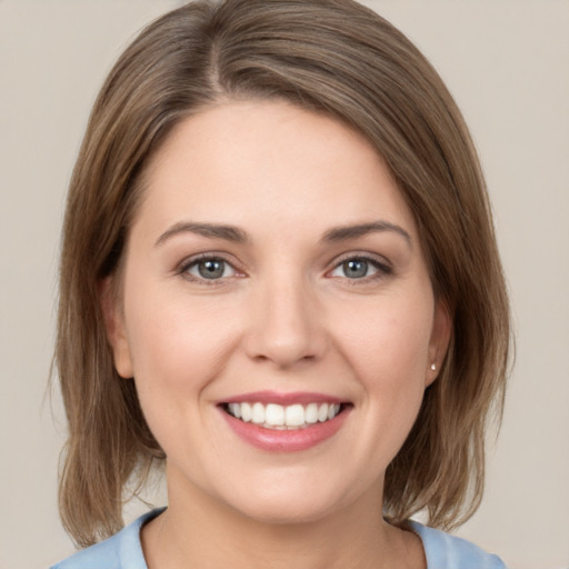 Joyful white young-adult female with medium  brown hair and grey eyes