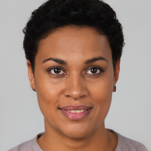 Joyful black young-adult female with short  black hair and brown eyes